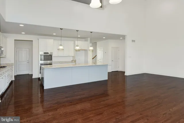 a kitchen with granite countertop white cabinets and stainless steel appliances