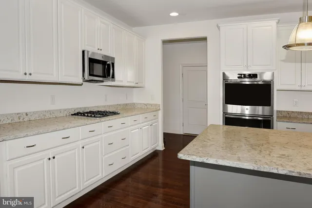 a kitchen with stainless steel appliances granite countertop a sink a stove and a refrigerator