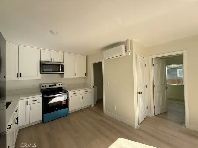 a kitchen with granite countertop white cabinets and stainless steel appliances