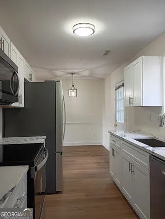 a kitchen that has a sink stainless steel appliances counter space and cabinets