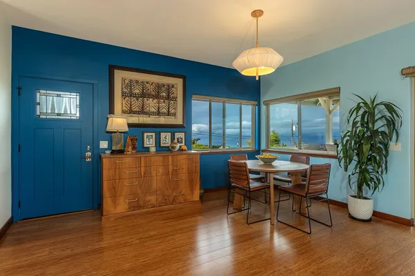 a kitchen with stainless steel appliances granite countertop a stove oven a dining table and chairs with wooden floor