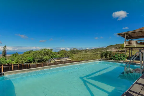 a view of a house with a yard from a swimming pool