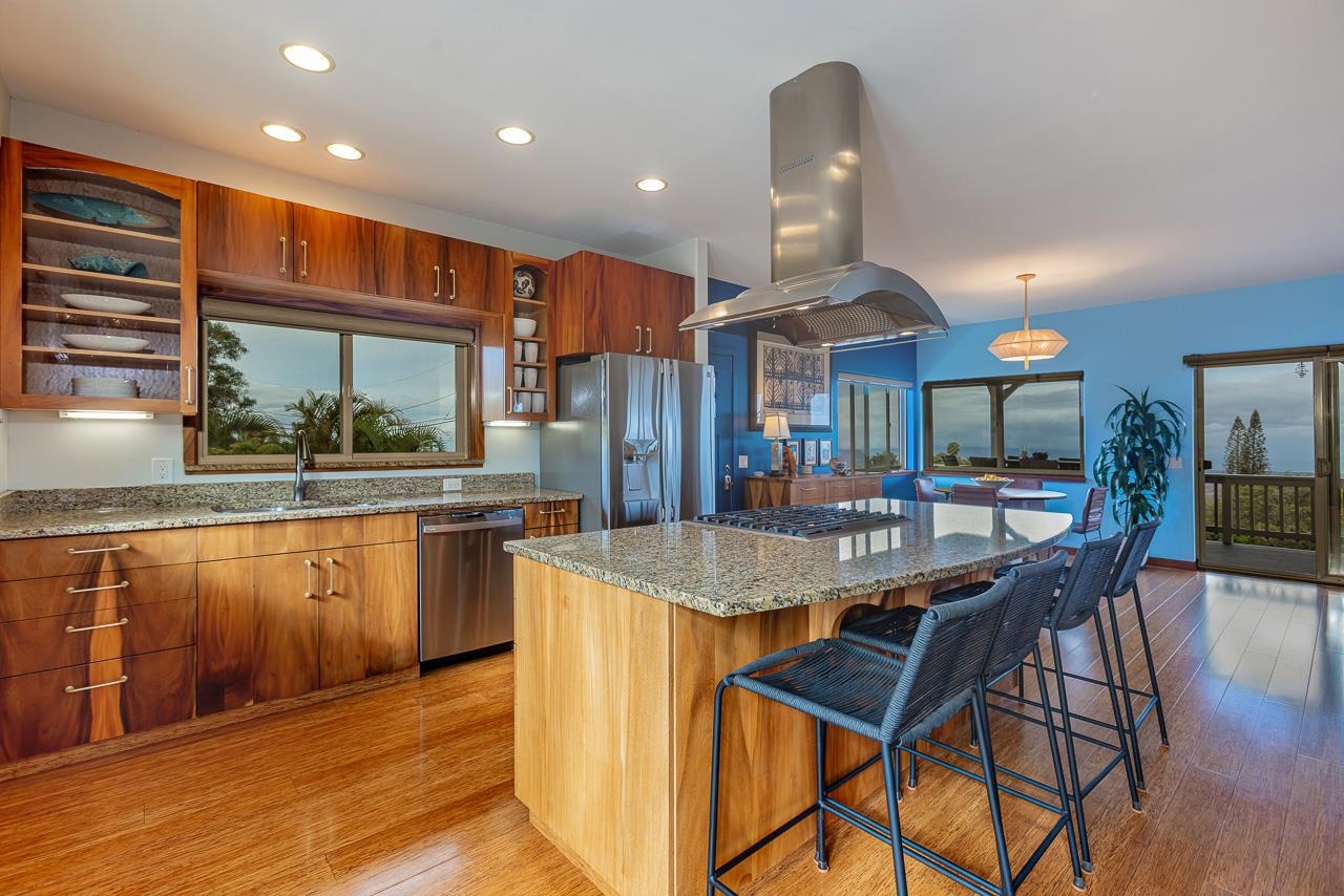 1350 Naalae Road Kula, HI 96790 - Photo 9 of 50 a kitchen with stainless steel appliances granite countertop a kitchen island a stove a table and chairs in it