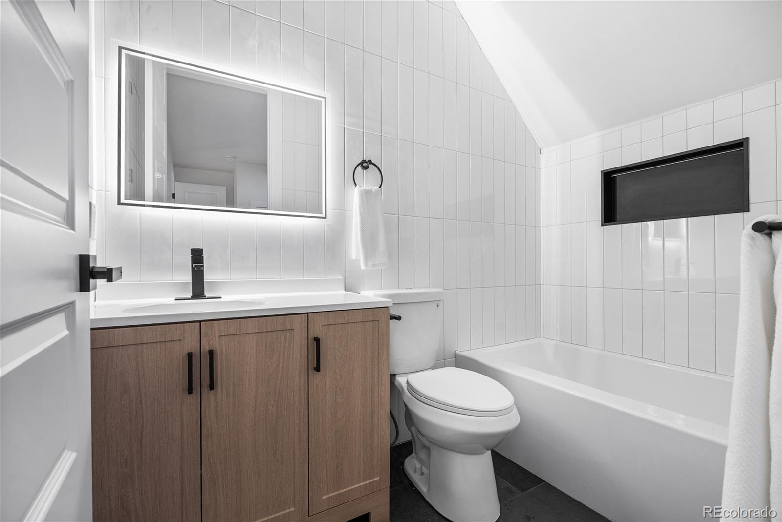 2011 West Scott Place Denver, CO 80211 - Photo 28 of 46 a bathroom with a toilet a sink a mirror a bathtub and vanity