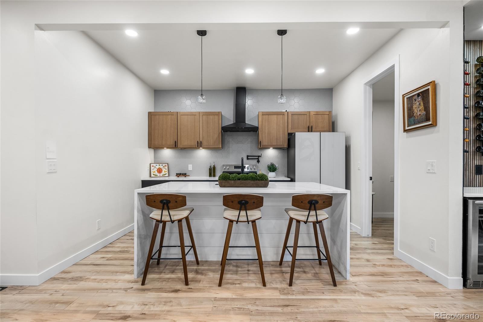 2011 West Scott Place Denver, CO 80211 - Photo 9 of 46 a kitchen with stainless steel appliances kitchen island a table chairs in it and wooden floors