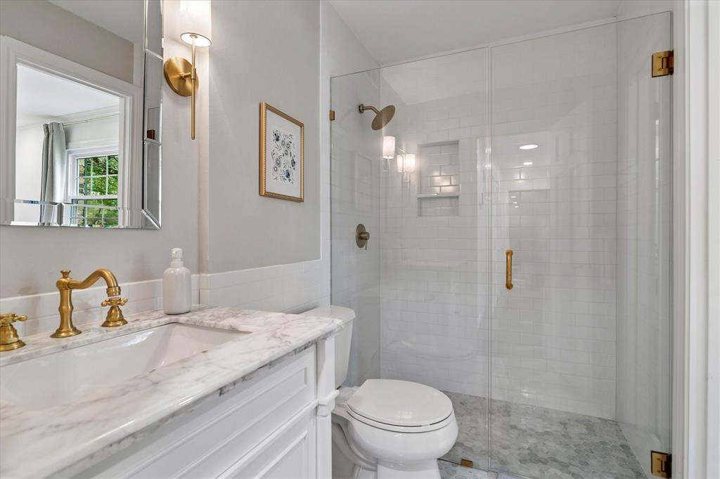 11439 Rosser Road Dallas, TX 75229 - Photo 23 of 35 a bathroom with a granite countertop sink a toilet and shower