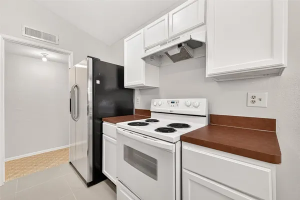 a kitchen with white cabinets and white appliances