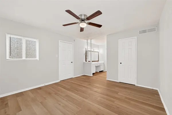 a view of a livingroom with a ceiling fan & wooden floor
