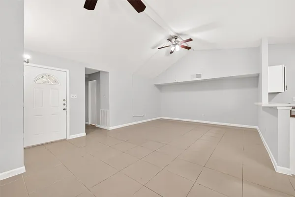 wooden floor in an empty room with a chandelier fan