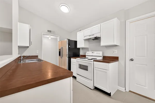 a kitchen with a white stove and refrigerator