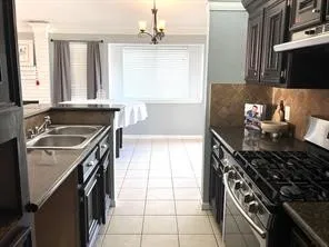 a kitchen with a sink stove top oven and cabinets