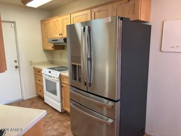 a white refrigerator freezer and a stove sitting inside of a kitchen