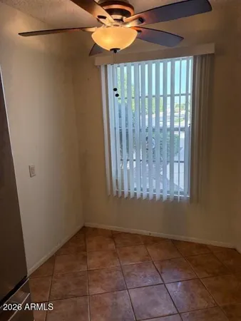 a view of a room has a window and a ceiling fan