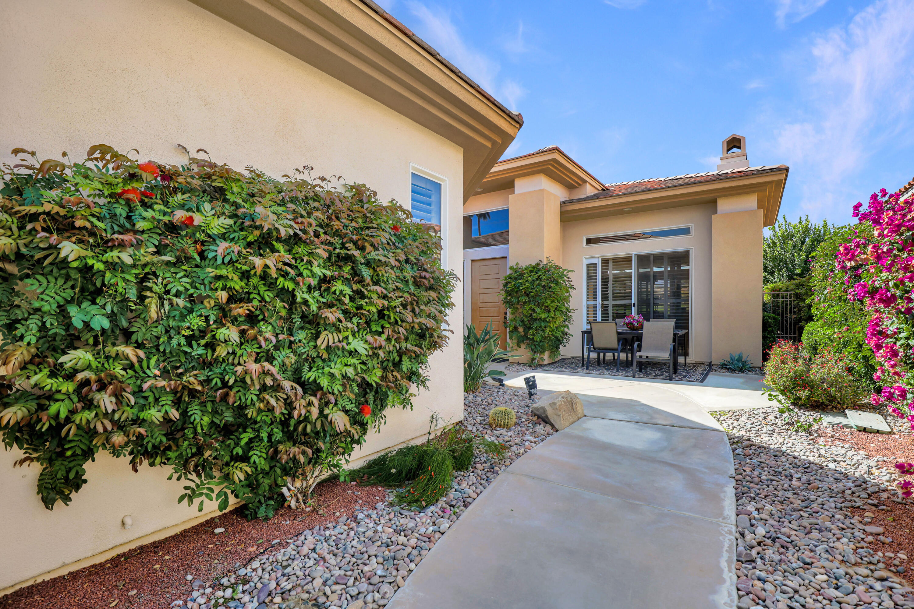 371 Tomahawk Drive Palm Desert, CA 92211 - Photo 5 of 34 a view of a house with potted plants and a bench
