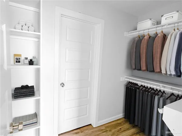 a view of walk in closet with clothes and shoes