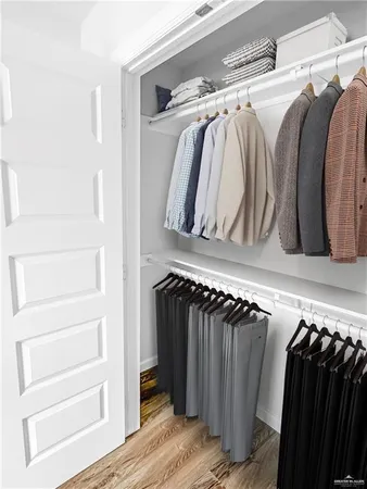 a view of walk in closet with clothes and shoes