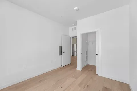a view of a room with wooden floor and white walls