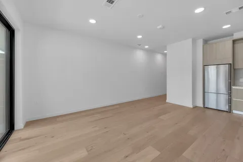 a view of an empty room with wooden floor