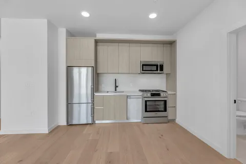 a kitchen with a refrigerator and a stove top oven