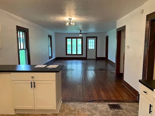 a view of a living room a hallway with wooden floor and chandelier