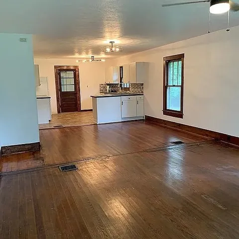 a view of a kitchen with a sink wooden floor and a window