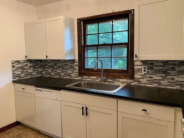 a kitchen with granite countertop a sink and a window