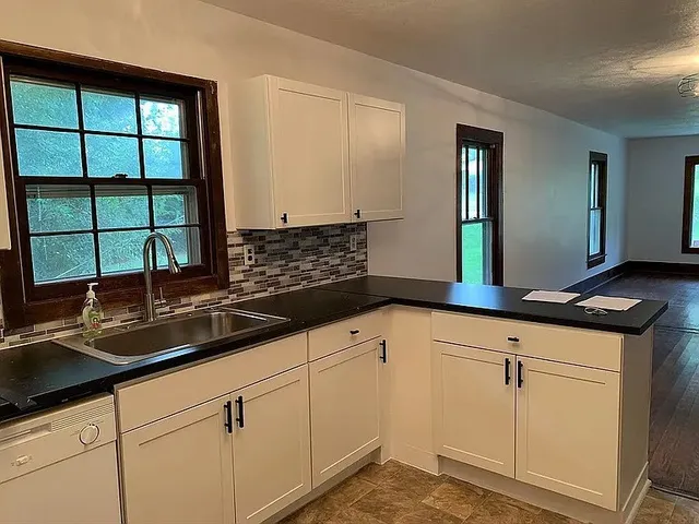 a kitchen with granite countertop a sink and a window