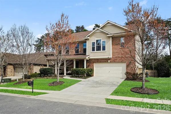 a front view of a house with a yard and trees