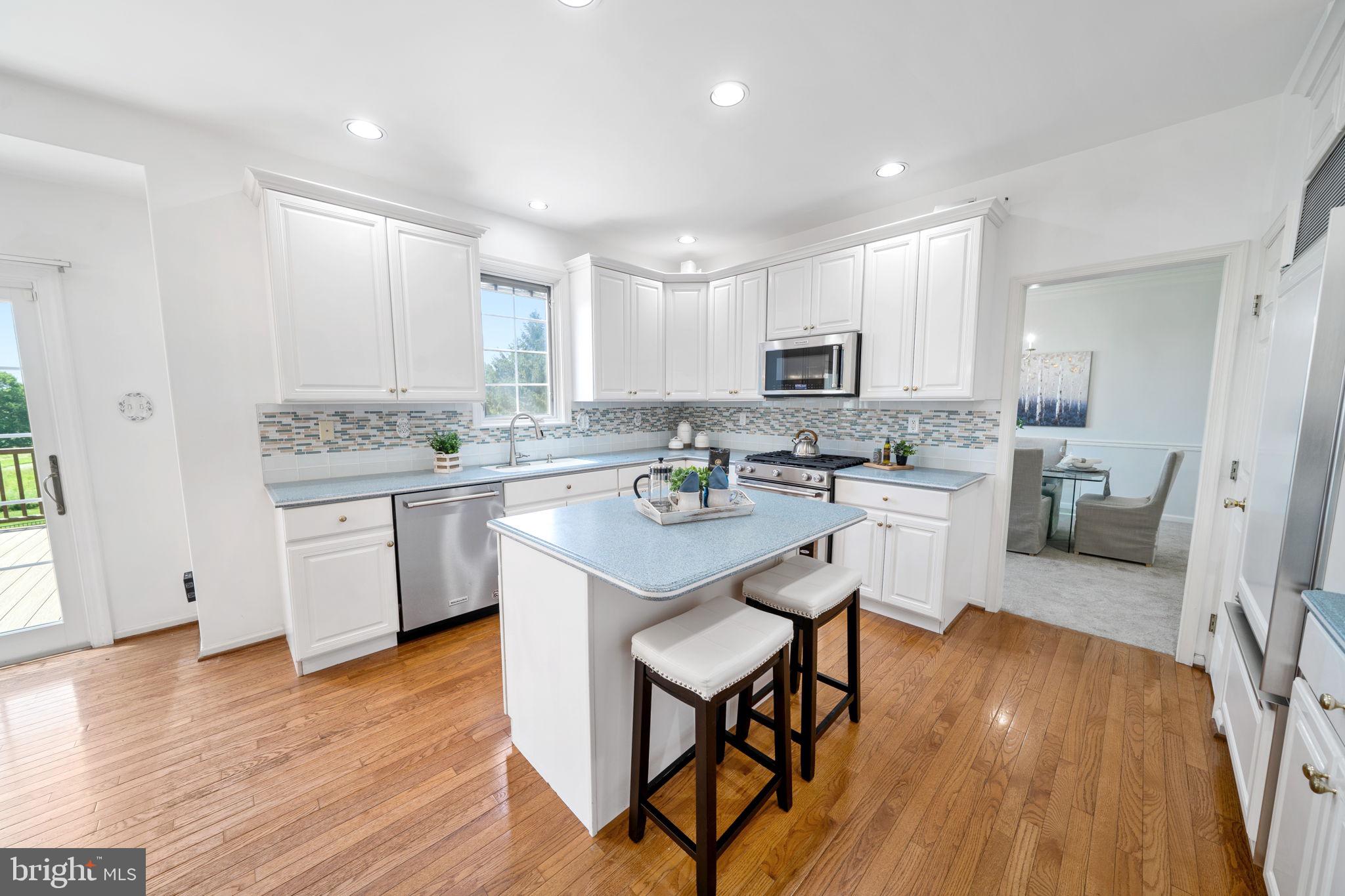 224 Laurel Heights Road Landenberg, PA 19350 - Photo 13 of 95 a kitchen with stainless steel appliances kitchen island granite countertop wooden floors and white cabinets