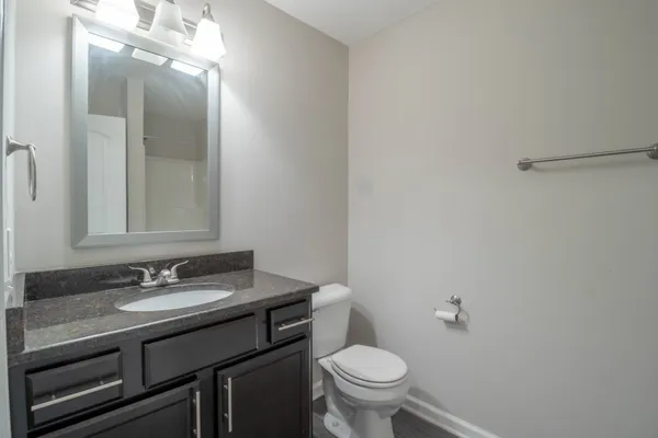 a bathroom with a sink a toilet and a mirror