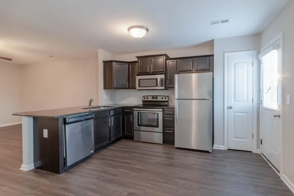 a kitchen with a refrigerator and a stove top oven