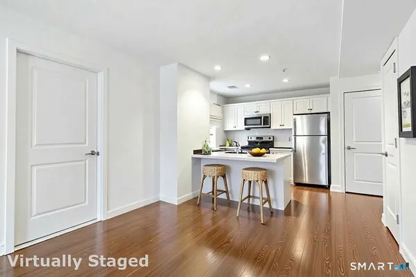 a kitchen with a refrigerator and white cabinets