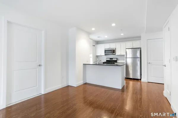 a kitchen with a refrigerator and a stove top oven