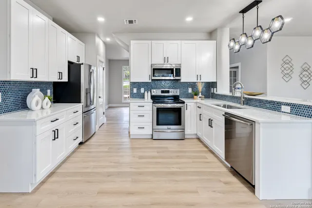 a large kitchen with stainless steel appliances granite countertop a stove oven and a sink