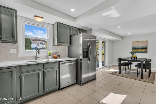 a kitchen with stainless steel appliances a refrigerator sink and microwave