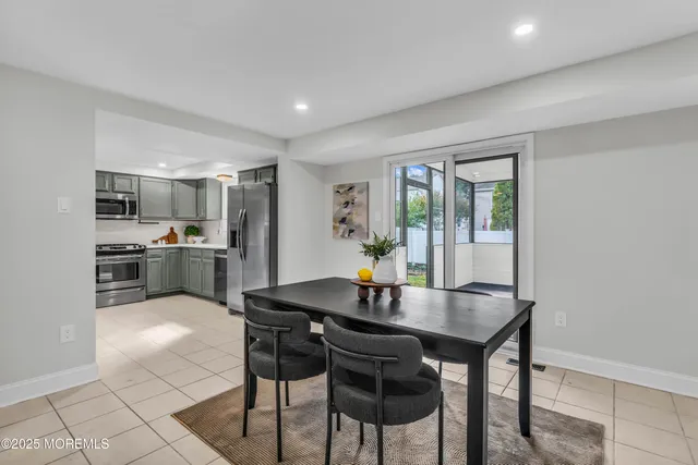a kitchen with a dining table chairs and refrigerator