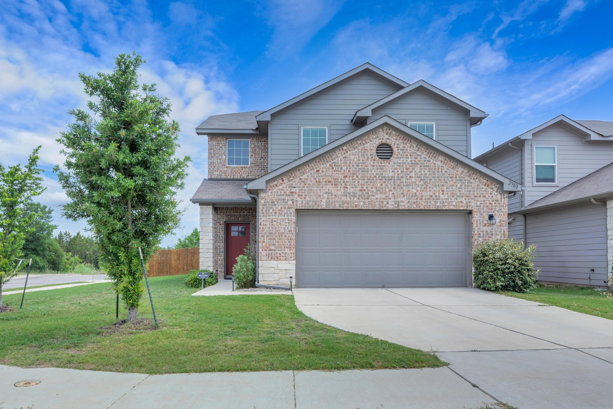 View of front of home with brick siding, driveway, and an attached garage