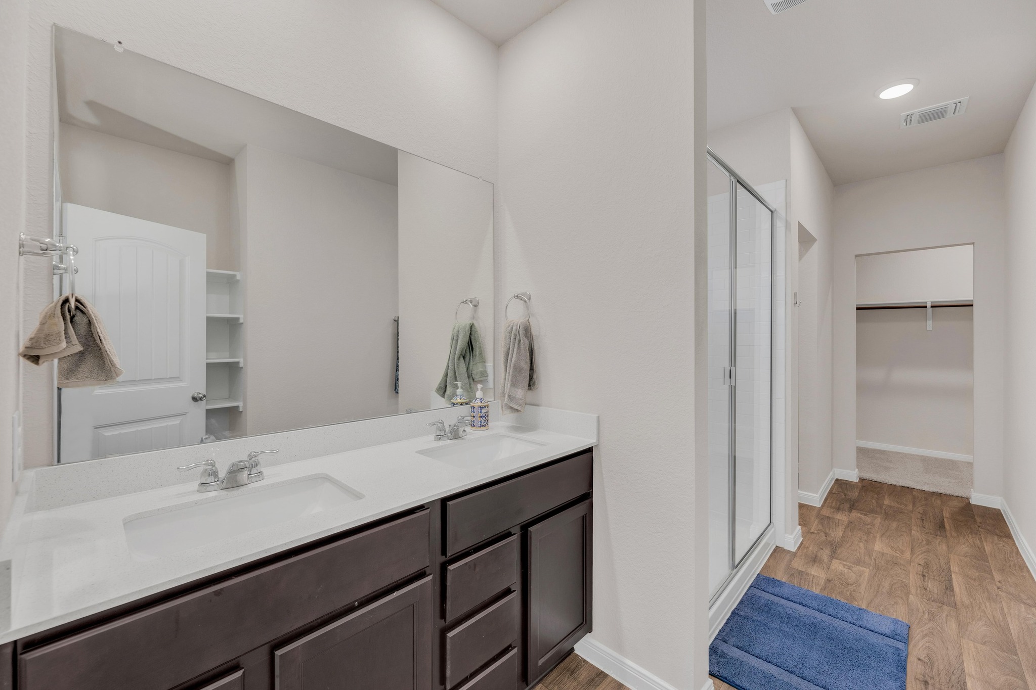 2900 Tweedy Trail Pflugerville, TX 78660 - Photo 14 of 33 Bathroom featuring a shower stall, a spacious closet, wood finished floors, double vanity, and baseboards