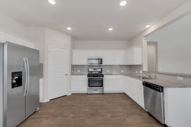 a kitchen with stainless steel appliances granite countertop a refrigerator and a sink