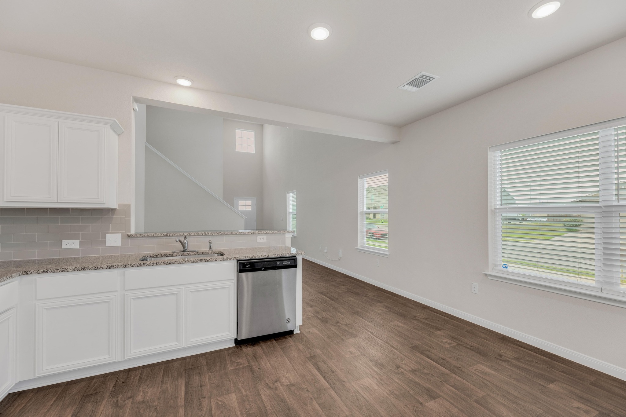 2900 Tweedy Trail Pflugerville, TX 78660 - Photo 9 of 33 Kitchen featuring dishwasher, a sink, white cabinets, dark wood-style floors, and recessed lighting