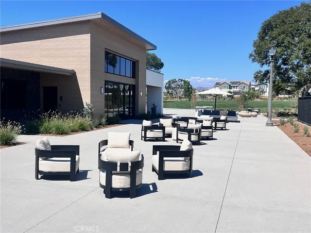 a living room with patio furniture and a fire pit