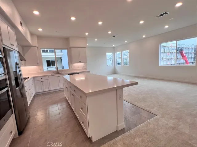 a kitchen with stainless steel appliances granite countertop a sink and a refrigerator