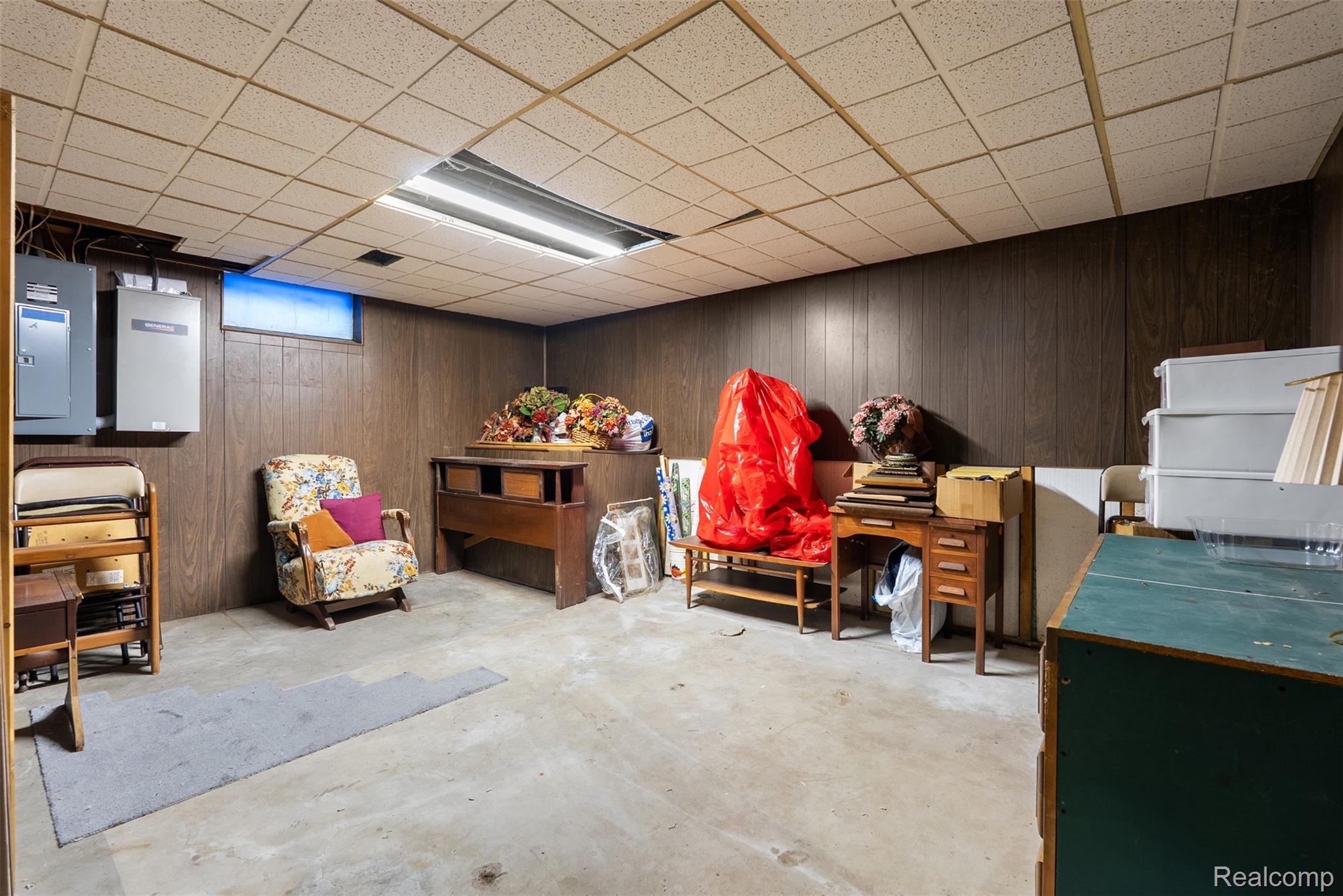 7192 Torrey Road Swartz Creek, MI 48473 - Photo 17 of 27 Miscellaneous room featuring wood walls, unfinished concrete flooring, a drop ceiling, and electric panel