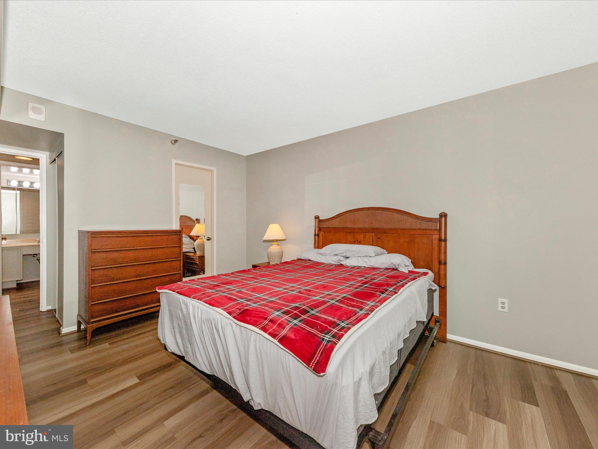 15101 Interlachen Drive, Unit 1116 Silver Spring, MD 20906 - Photo 23 of 78 a bedroom with a bed and wooden floor
