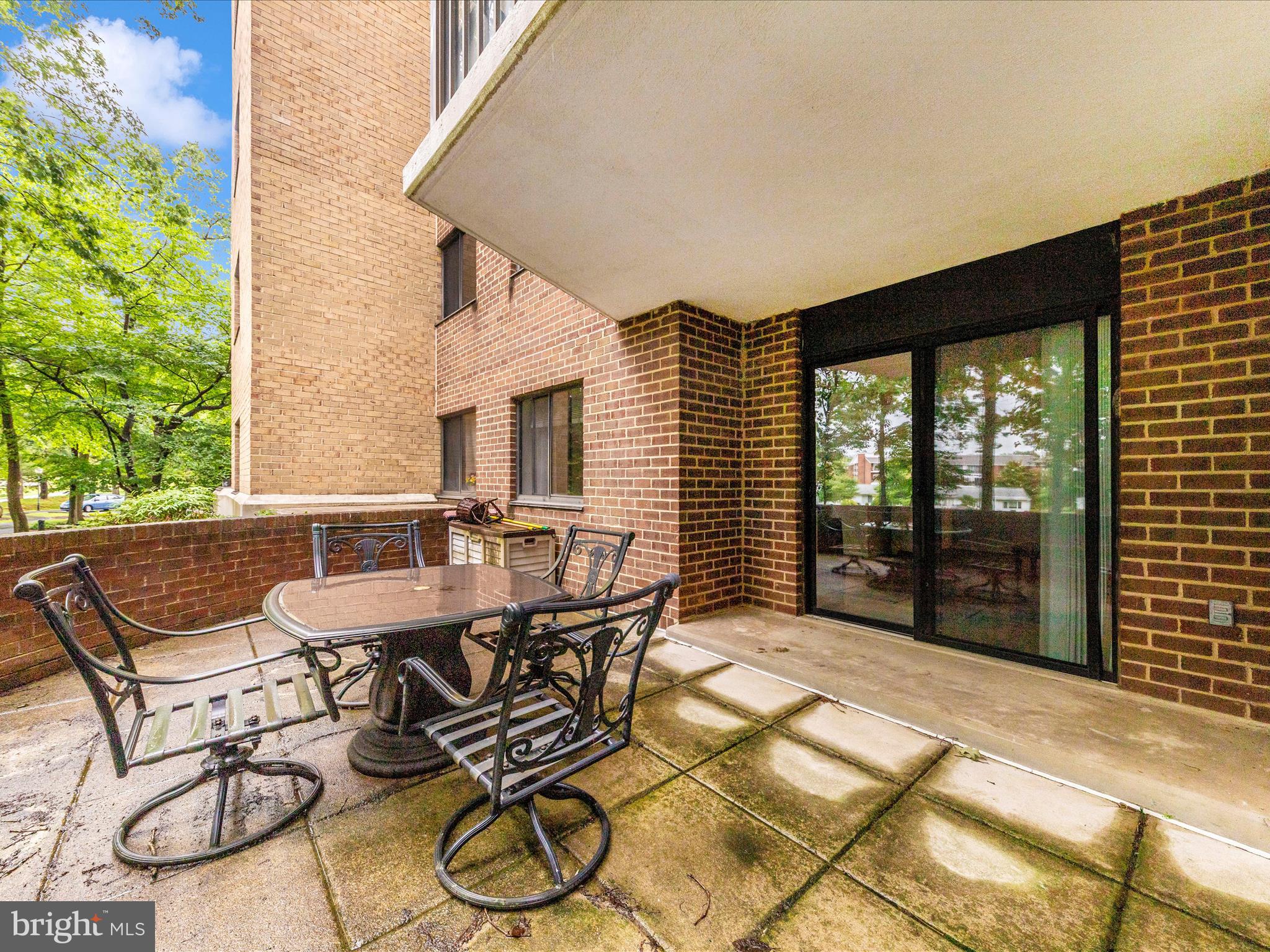 15101 Interlachen Drive, Unit 1116 Silver Spring, MD 20906 - Photo 31 of 78 a view of a patio with table and chairs with wooden floor and fence