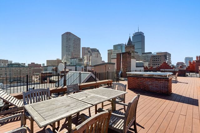 a view of a roof deck with furniture
