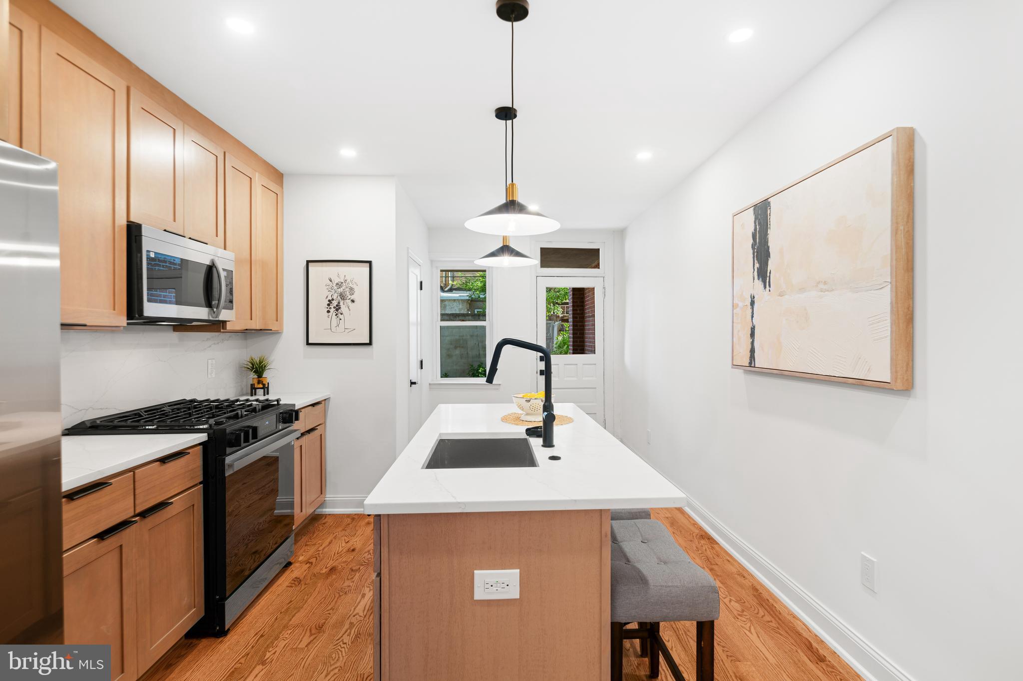 914 Moore Street Philadelphia, PA 19148 - Photo 8 of 26 a kitchen that has a sink a stove and chairs