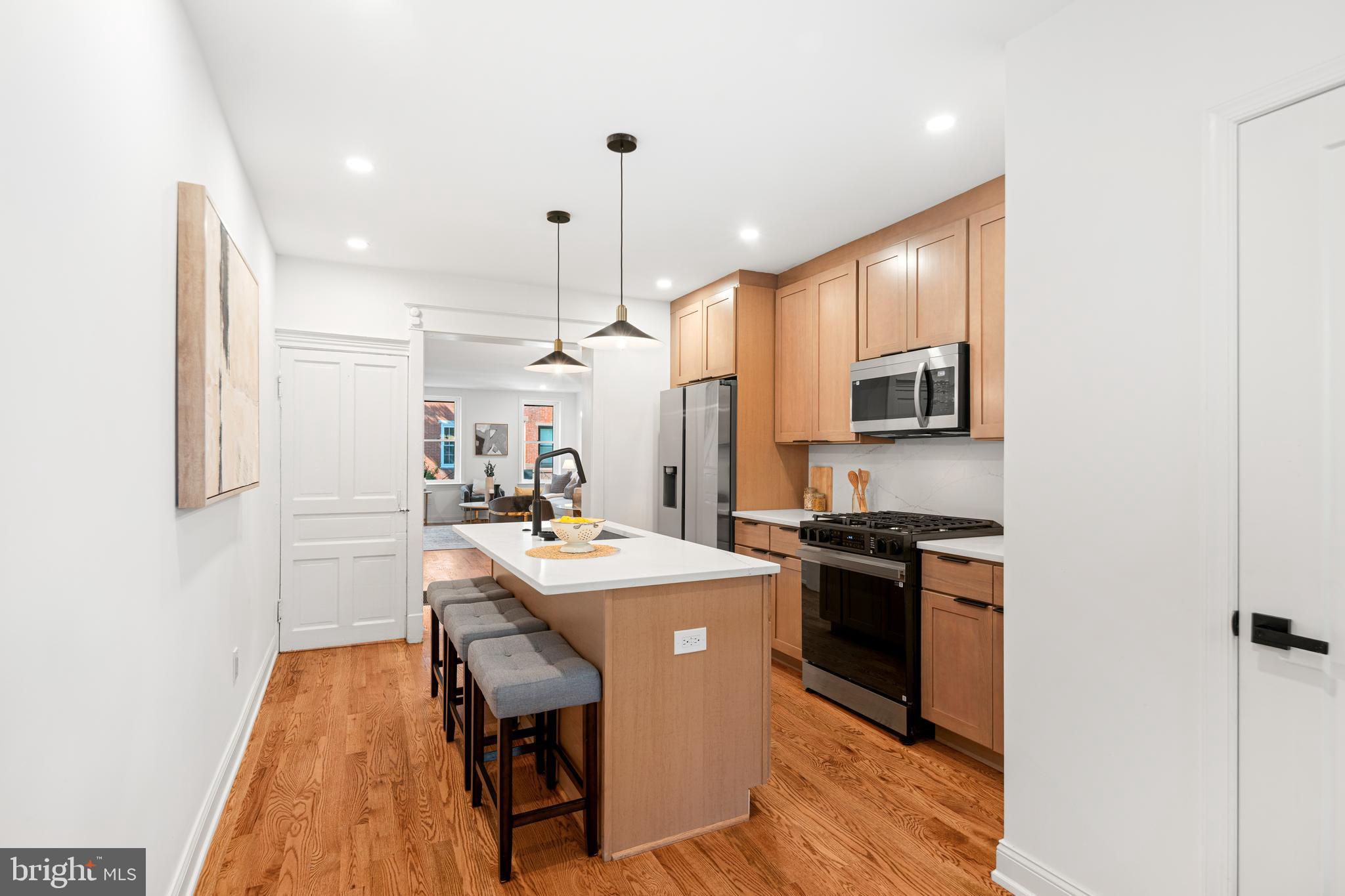 914 Moore Street Philadelphia, PA 19148 - Photo 9 of 26 a kitchen with stainless steel appliances a stove a sink a refrigerator wooden floor and cabinets