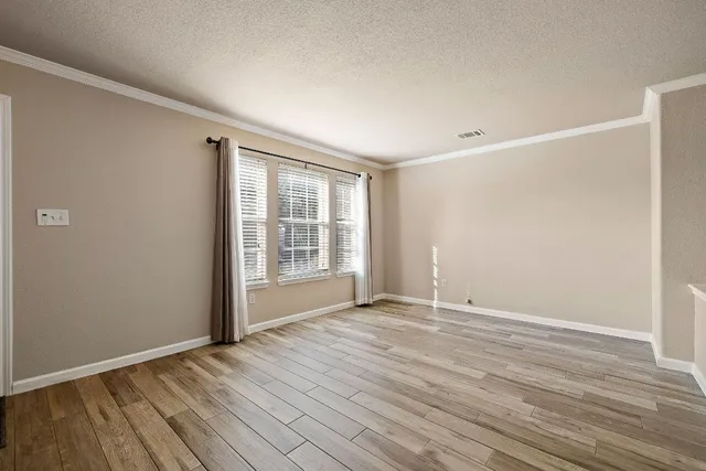 a view of an empty room with wooden floor