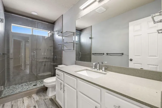 a bathroom with a double vanity sink toilet and shower